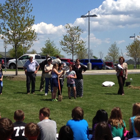 The poster artist speaks to her classmates as they prepare to plant the 15 trees awarded.